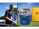 Blue and yellow dunk tank rental in Houston with mesh cage top, ideal for interactive entertainment at Kingwood parties