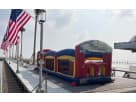 Red and blue inflatable obstacle course rental with slide at a Dallas waterfront, ideal for large group events in Arlington.