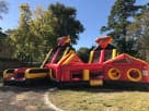Red and yellow dual-slide obstacle course rental in Austin perfect for kids' parties, ideal for Round Rock backyards.