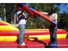 Red and yellow Bungee Run & Joust Combo interactive bounce house rental in Austin, ideal for kids ages 5+ and large events.