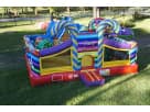 Colorful candy-themed toddler bounce house rental in Dallas backyard with blue striped towers, ideal for small children's parties