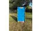 Blue inflatable climbing wall with circular handholds in a residential Austin backyard, ideal for carnival game rentals popular
