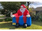 Silla inflable gigante de Papá Noel en renta en Austin, perfecta para fotografías en fiestas navideñas de Round Rock.