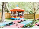 Carousel bounce house rental in Houston with hand-painted horse details, ideal for Sugar Land carnival-themed parties.