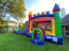 Perfect for Dallas parties, this colorful rainbow bounce house rental features a wet or dry slide with vibrant castle towers