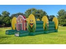 Bright corn-themed obstacle course bounce house rental for Austin featuring red, yellow, and green sections, perfect for Georgetown events.