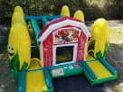 Colorful barn bounce house with corn slide lanes available for rental in Austin, perfect for Kyle backyard celebrations.