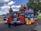 Perfect for carnival-themed parties in Austin, this colorful amusement park obstacle course rental features dual slides