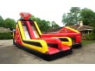 Red and yellow double rush obstacle bounce house rental in Dallas, perfect for Plano backyard birthday celebrations.