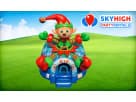 Colorful elf-themed bounce house rental in Austin with red, green, and blue sections, perfect for kids' birthday parties in Round