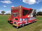 Perfect for Houston kids' parties, this fire truck bounce house rental features a wet or dry slide with brick fire station facade.