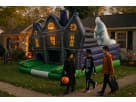 Haunted House Maze bounce castle rental in Austin with illuminated windows and ghost figure, perfect for all-ages Halloween