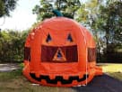 Pumpkin bounce house rental in Dallas with bright orange jack-o'-lantern design, ideal for Garland fall parties and Halloween