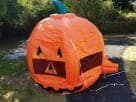 Perfect for fall festivals in Dallas, this bright orange pumpkin bounce house rental features jack-o'-lantern details