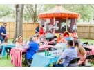 Carnival carousel moonwalk rental in Houston backyard with red and gold horses, ideal for children's birthday parties in Cypress.