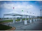 White 15x15 high peak tent rental in Houston with colored flags, seats up to 37 guests for outdoor weddings and events.