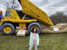 Yellow dump truck bounce house with wet/dry capability at a Dallas backyard party rental, ideal for Irving.