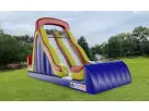 Colorful 18ft dual lane dry slide rental in Houston featuring a rock climb feature, positioned in a residential park
