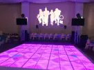 Pista de baile LED personalizable en renta en Houston, ideal para graduaciones con iluminación púrpura y estaciones DJ.