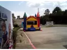 Colorful castle bounce house rental in Dallas with attached slide, ideal for Plano birthday parties and family events.