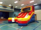 Colorful 16ft double slide water rental set up indoors in Austin, ideal for wet or dry backyard fun in San Marcos.