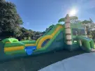 Green and yellow dinosaur bounce house water slide rental for Buda backyard parties with castle-themed design.