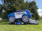 Renta de brincolín Police Cruiser con tobogán ideal para fiestas en Austin, perfecto para niños de 3 a 12 años.