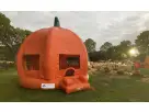 Bright orange pumpkin bounce house rental in Dallas with green stem, ideal for fall festivals and Fort Worth parties.