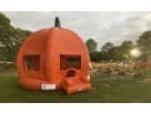 Bright orange pumpkin bounce house rental in Dallas with green stem, ideal for fall festivals and Fort Worth parties.