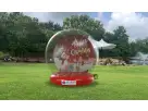 Inflatable Christmas snow globe rental with festive lights at an Austin park—perfect for holiday parties in Buda.