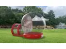 Red and clear bubble bounce house with Christmas lights available for rental in Austin—perfect for holiday parties
