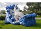 Gone Fish'n shark water slide rental in Houston with wet and dry capability, set up on a grass lawn ideal for Sugar Land parties.
