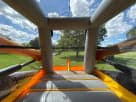 Dual-lane water slide rental in Buda featuring orange and black design with protective entry cover.