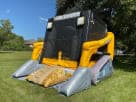 Skid Loader construction bounce house rental in Austin with dual slides—perfect for kids' birthday parties in San Marcos.