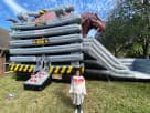 Perfect for The Woodlands birthday parties, this dinosaur T-Rex bounce house rental in Houston features dual slides