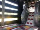 T-Rex bounce house rental in Houston with colorful foam floor pads, ideal for League City birthday parties and events.