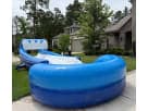 Blue and white water slide rental with attached pool basin displayed in a Houston backyard, ideal for summer parties in Pasadena.