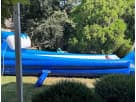 Bright blue dual-lane water slide rental in Houston with attached tank—ideal for Katy parties and backyard fun.
