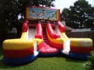Toy Story 16ft dual slide bounce combo rental in Round Rock—bright red, yellow, and blue inflatable ideal for Austin parties.